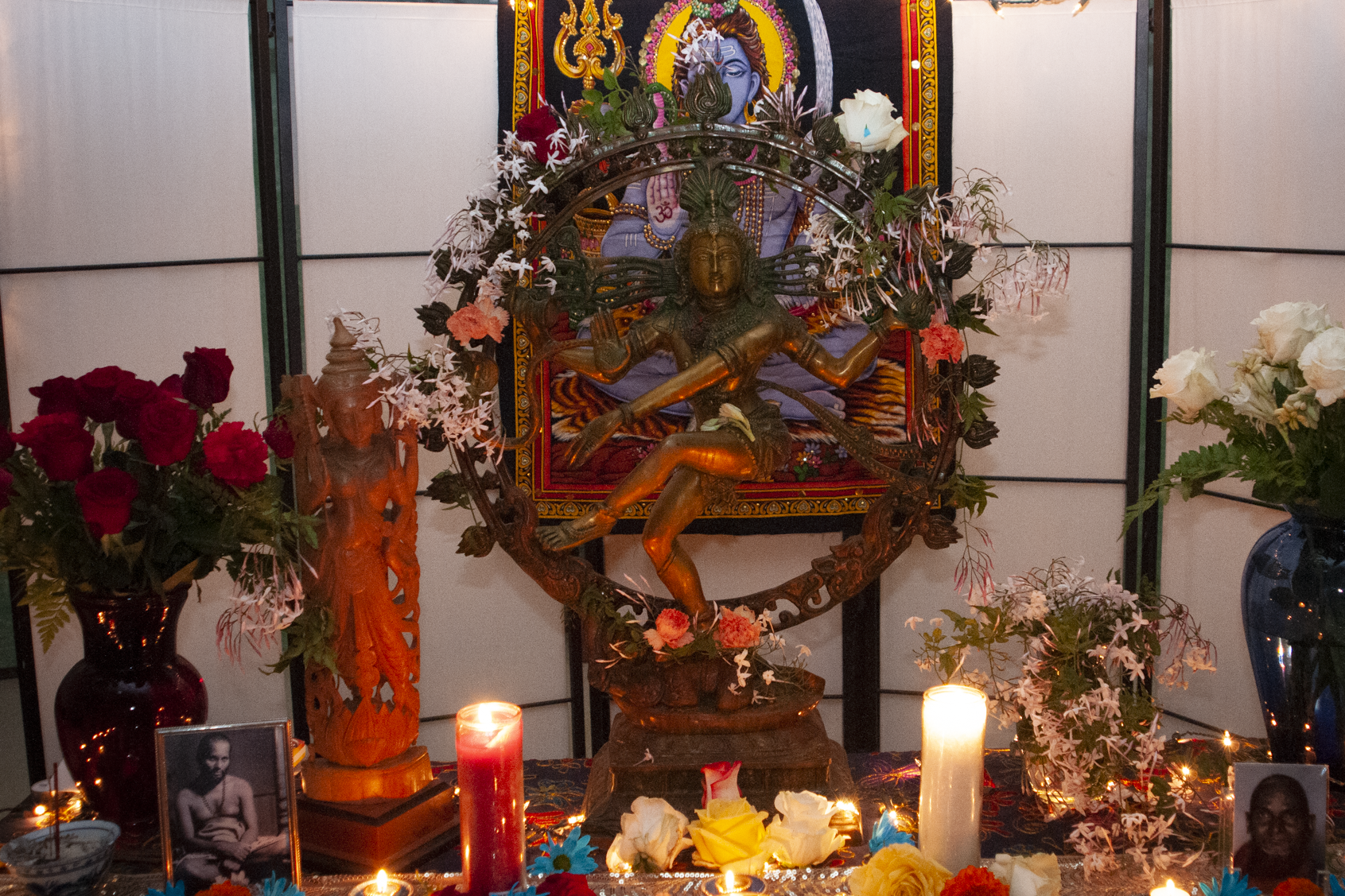 Nataraja statue shrine with candles and flowers used in tantric meditation.